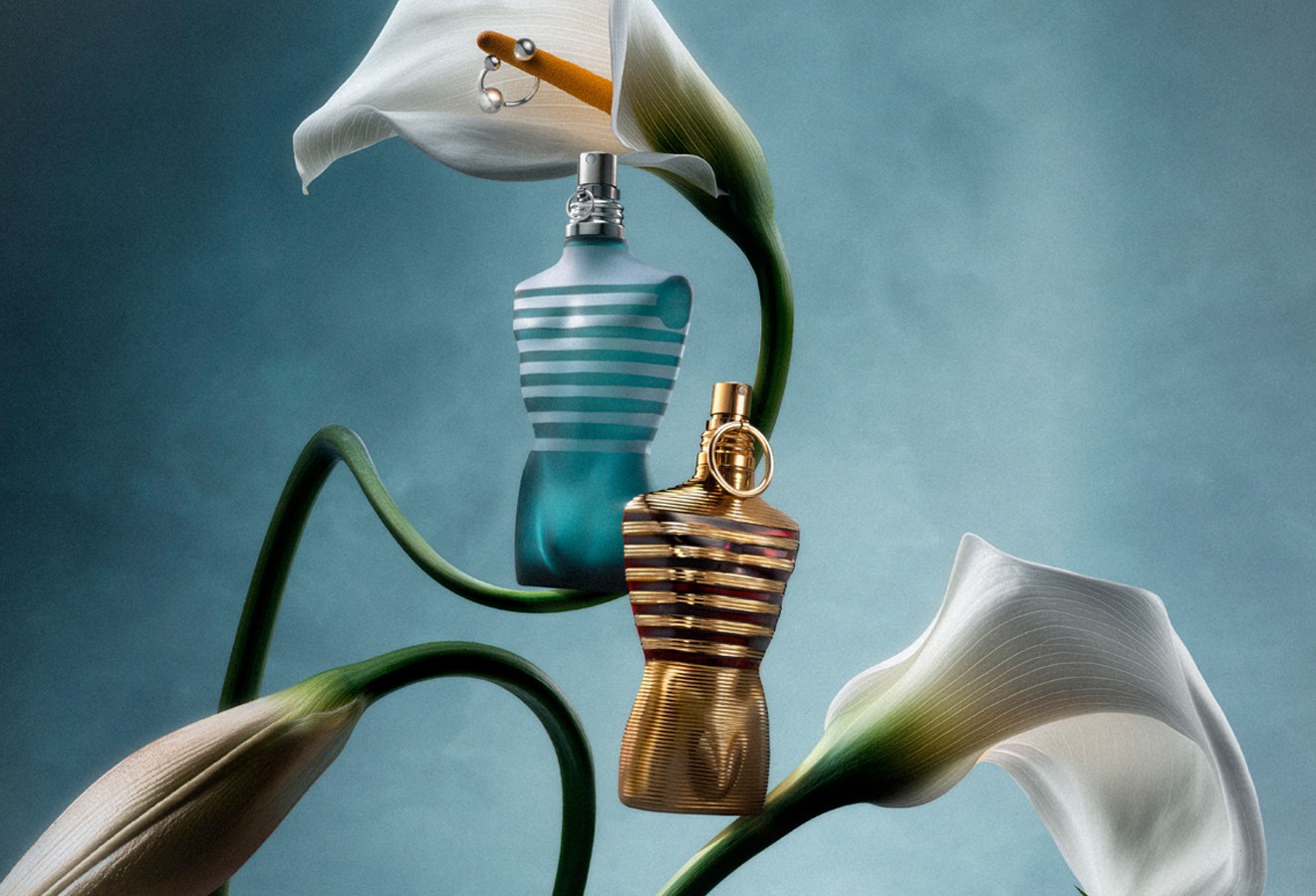 Le Male and Le Male Elixir surrounded by flowers on a blue background